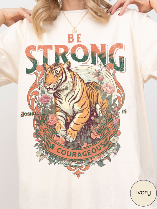 A person wearing a white t-shirt with a graphic design featuring a tiger surrounded by flowers and text.
