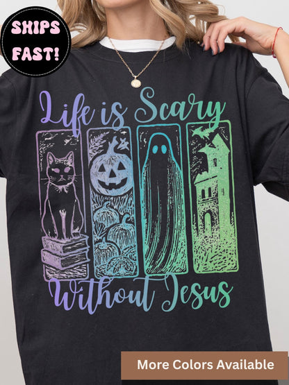 The image is a black t-shirt with a graphic design featuring a cat, a jack-o-lantern, a ghost, and a castle. The text on the t-shirt reads &quot;Life is scary without Jesus&quot;.