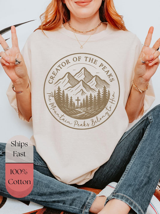 Faith-based Comfort Colors tee with mountain peaks and trees, “Creator of the Peaks” message, great Christian gift for nature lovers, hikers, and spiritual adventurers.