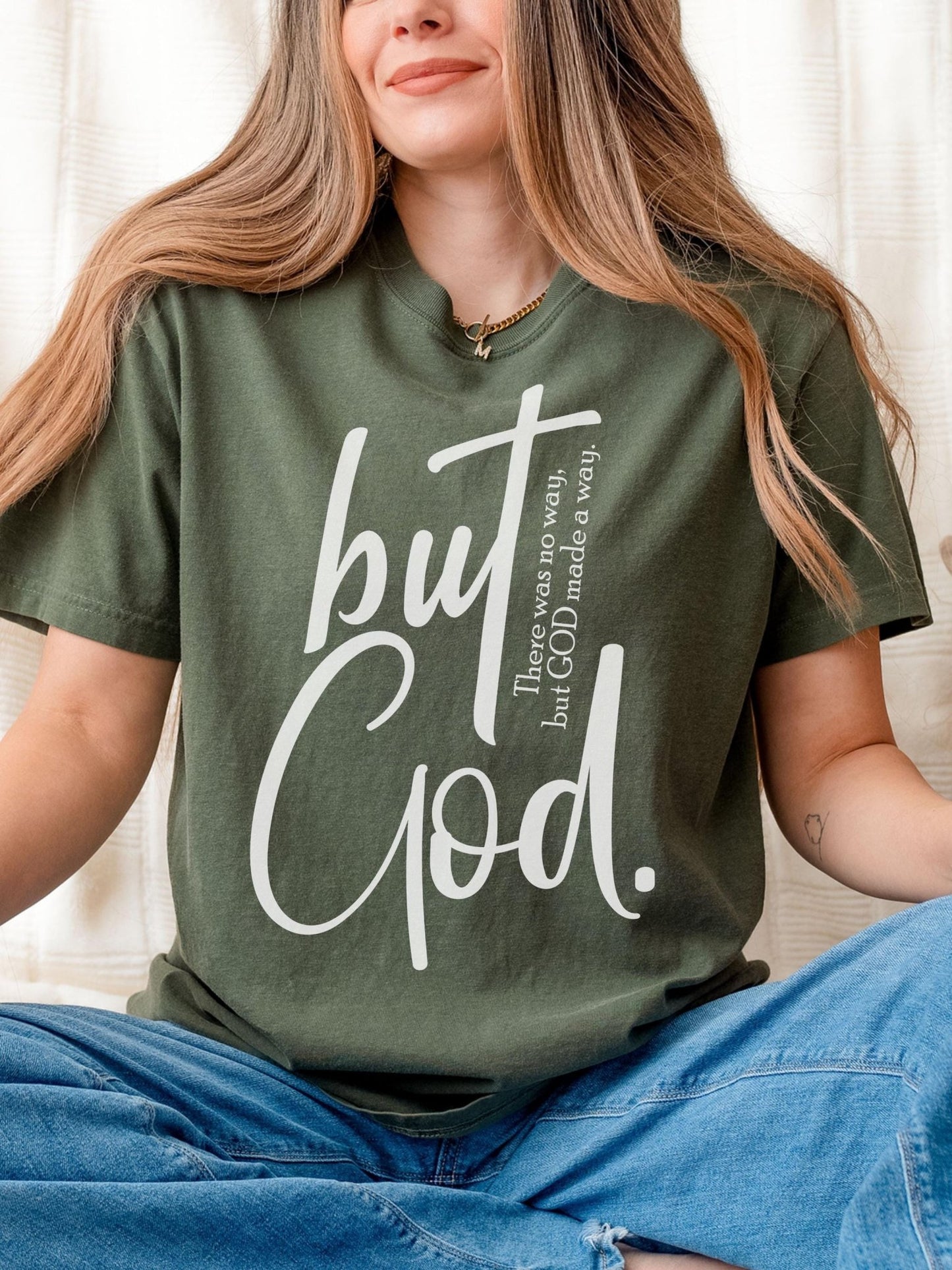 Oversized Christian t-shirt featuring But God quote in large script font on soft moss green fabric perfect for Jesus lovers and faith driven fashion