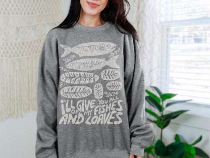 A woman wearing a grey sweatshirt with a graphic design of fish and the text &quot;I&#39;ll give you all of my fish and leaves&quot;.