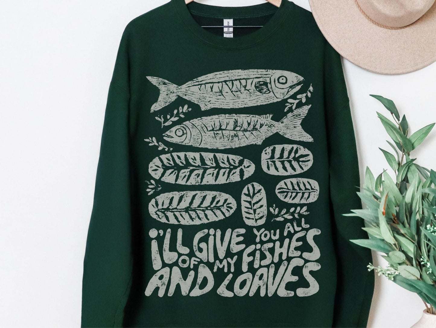 A dark green sweatshirt with a graphic design of fish and leaves, along with the text &quot;I&#39;ll give you all of my fish and leaves&quot;.