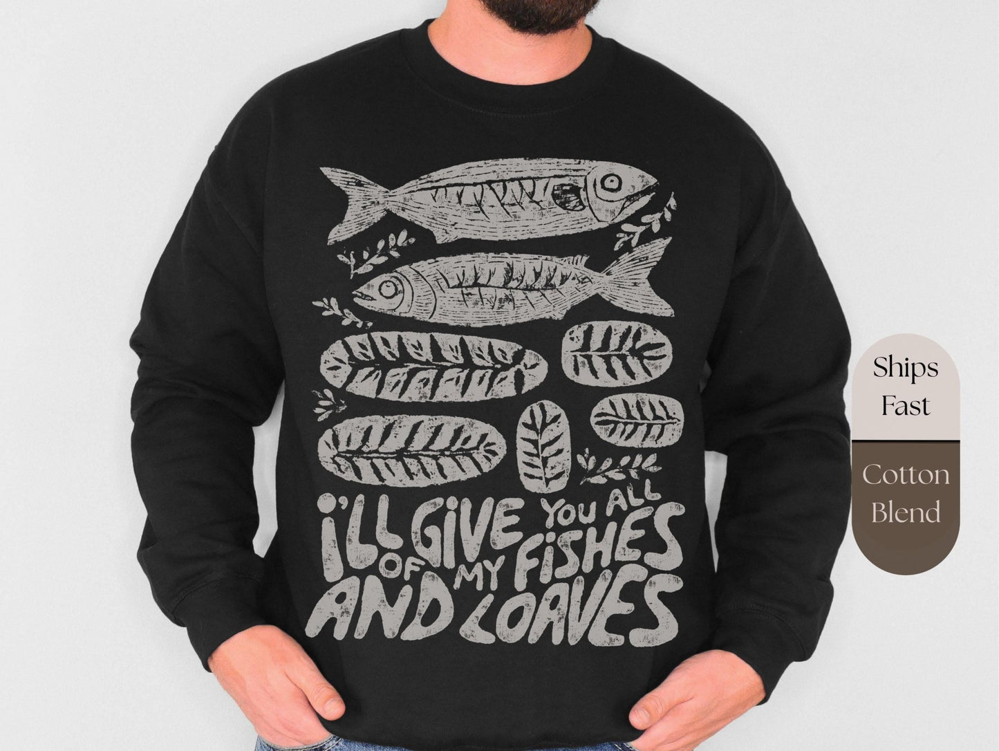 a black long-sleeved shirt with a graphic design depicting fish and leaves, along with the text &quot;I&#39;LL GIVE YOU ALL OF MY FISHES AND LOAVES&quot; printed on it.