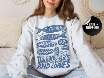 A woman wearing a gray sweatshirt with a blue fish design and text on it, sitting on a couch.