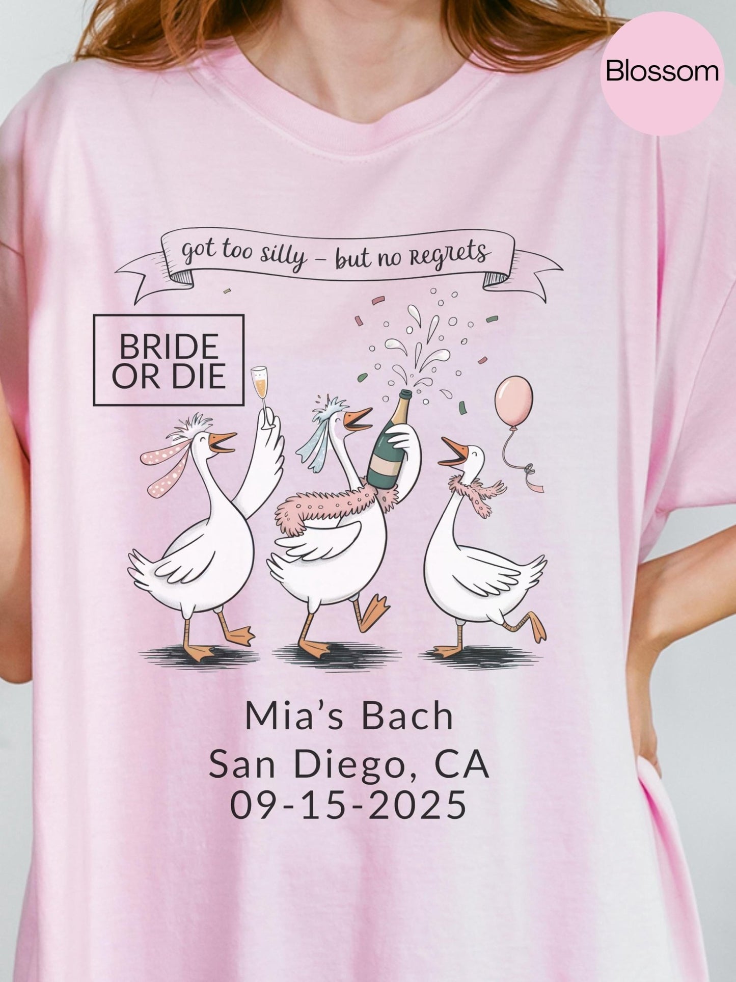 A pink t-shirt with a graphic design featuring three cartoon geese celebrating, along with text that reads &quot;got too silly - but no regrets&quot; and &quot;Mia&#39;s Bach San Diego, CA 09-15-2025&quot;.