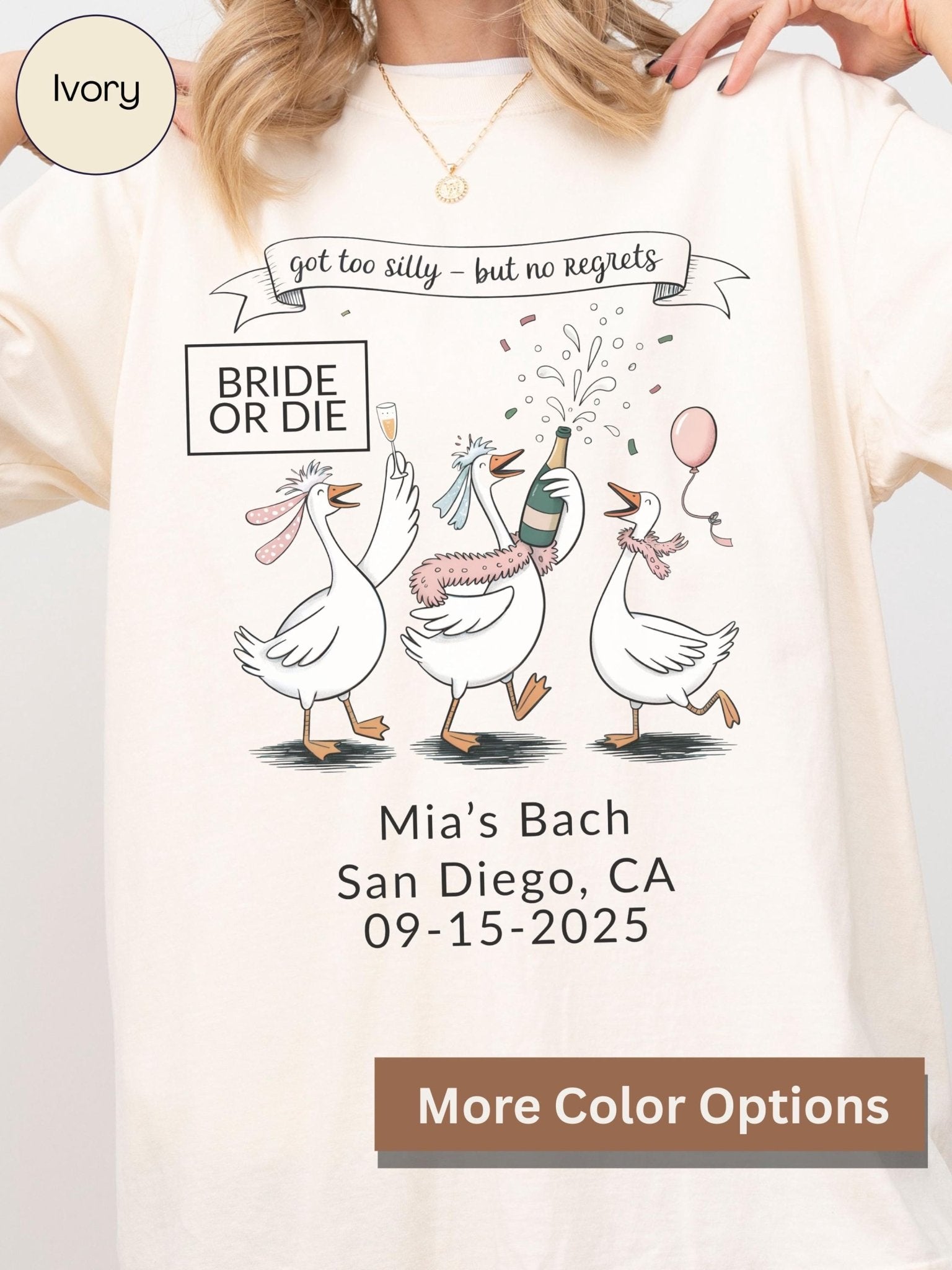 A white t-shirt with a graphic design featuring three cartoon geese, one of which is holding a champagne bottle, celebrating what appears to be a wedding or engagement party.