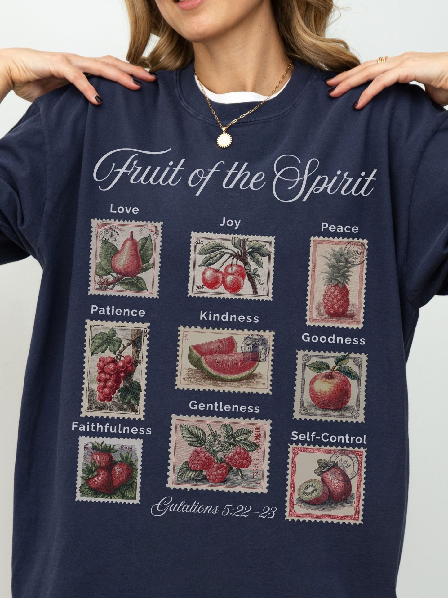 A woman wearing a navy blue sweatshirt with a graphic design depicting the fruit of the spirit and its associated values.