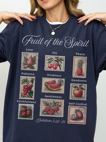 A woman wearing a navy blue sweatshirt with a graphic design depicting the fruit of the spirit and its associated values.
