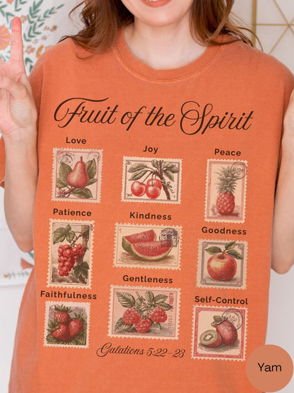 a person wearing an orange t-shirt with a graphic design depicting various fruits and their associated Bible verse.