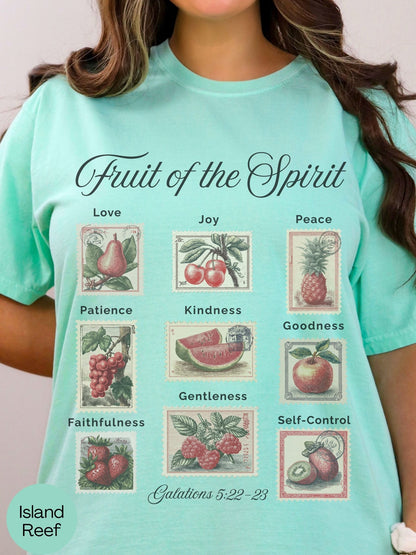 A woman wearing a turquoise t-shirt with a graphic design depicting the fruit of the spirit and its associated qualities.