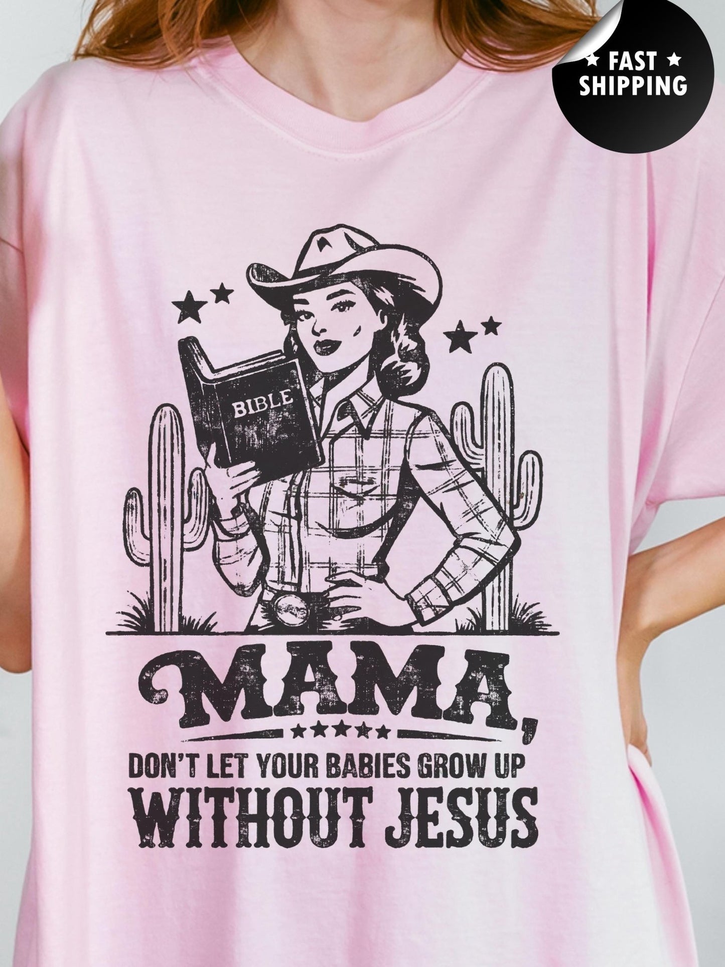A woman wearing a pink t-shirt with a graphic design depicting a woman holding a Bible and a cowboy hat, along with the text "MAMA, DON'T LET YOUR BABIES GROW UP WITHOUT JESUS".