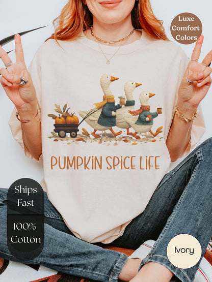 A woman wearing a white t-shirt with a pumpkin spice life graphic and text, making a peace sign with her hands, and posing for the camera.