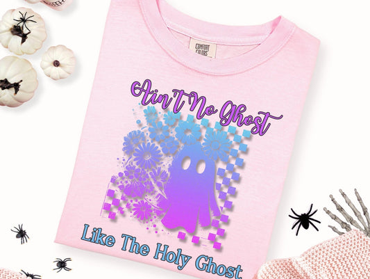 a pink t-shirt with a graphic design of a purple and blue ghost surrounded by flowers and a text overlay that reads "Ain't No Ghost Like The Holy Ghost".