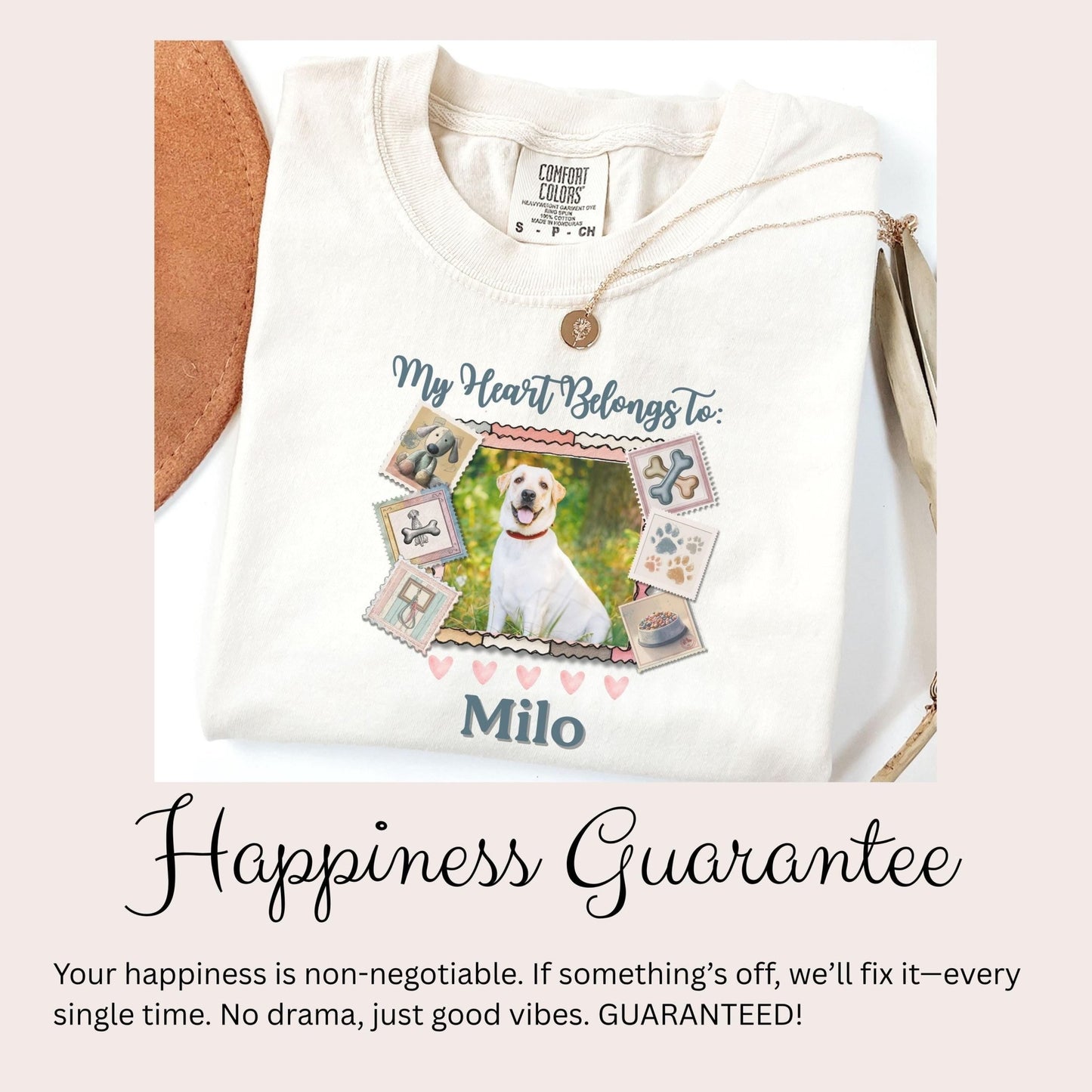 A white t-shirt with a graphic design featuring a dog and various other images, along with text that reads &quot;My Heart Belongs to Milo&quot; and &quot;Happiness Guarantee&quot;.