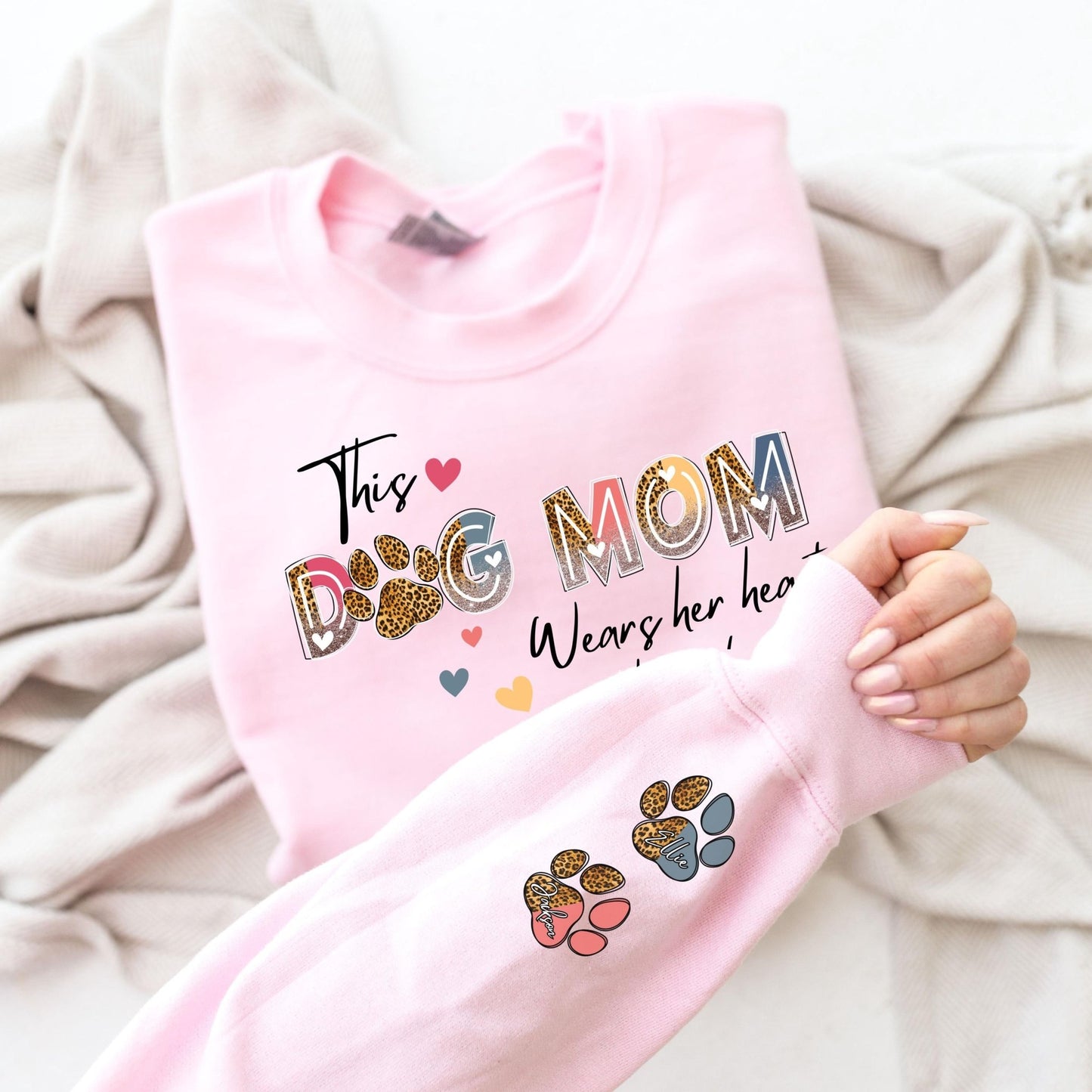 Cozy and stylish dog mom sweater with customizable paw prints and pet names, designed as a thoughtful gift for women who love their pets.