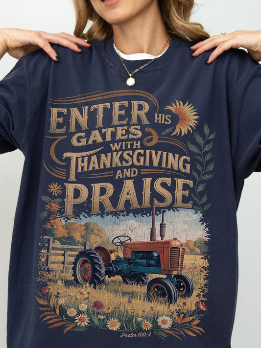 a woman wearing a blue sweatshirt with a graphic design depicting a tractor in a field, surrounded by flowers and foliage.