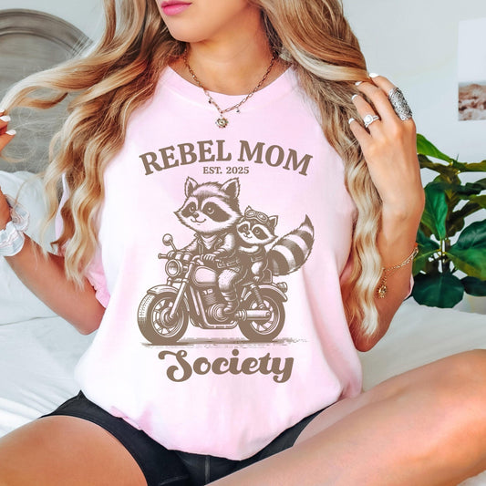 Rebel Mom Society t-shirt featuring a cute raccoon motorcycle graphic, designed for bold moms who love a trendy Comfort Colors graphic tee with a custom “Est” year print